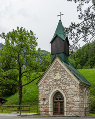 small chapel with stone walls and a green roof