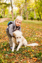 Little animal lover on a autumn walk with pet dog