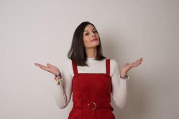 Maybe yes or no. Doubtful fashionable girl shrugs shoulders in bewilderment, tries to make decision...