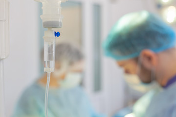 Hospital. Surgeon operates in the operating room. Dropper on a blurry background with operating doctors
