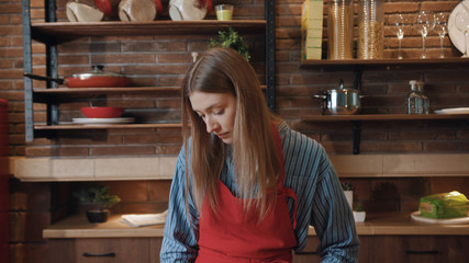 Portrait of pretty young caucasian woman cook look at camera preparing dinner in modern kitchen at home.