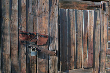  Old wooden boarded up door with padlock
