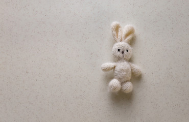 handmade. knitted white bunny on a white background