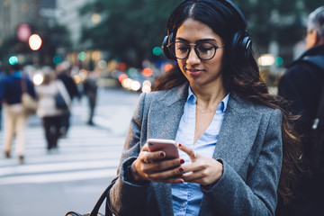 Young woman enjoying listening to music through headphones