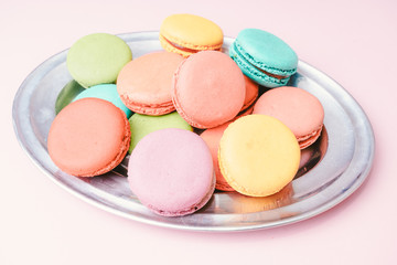 Multicolored macaroons on pink background. Sweet and colourful french macaroons
