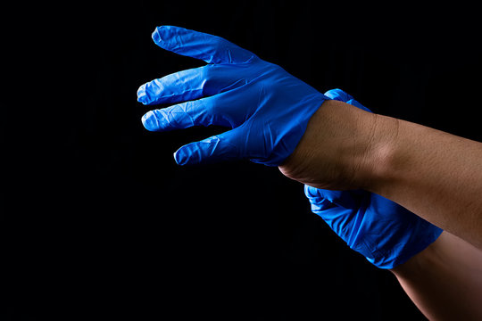 Hands wearing blue rubber gloves