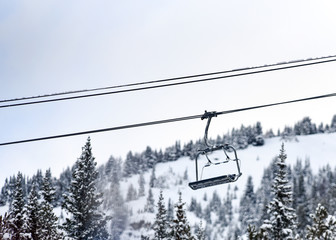 Chair lift above snowy trees at ski resort
