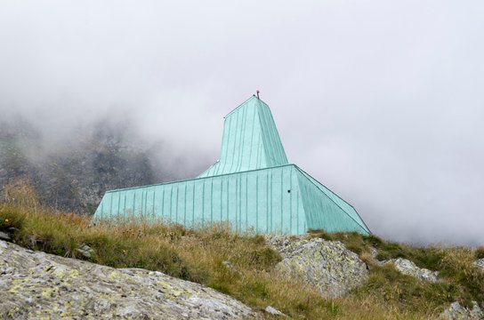 Green metal shelter on the shore of lake Caltun in the Carpathians, Romania