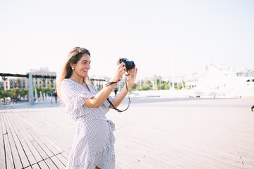 Smiling woman taking picture in street