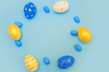 Easter golden decorated eggs on blue background.