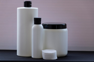 Mockup. White bottles for shampoo and masks for hair or other beauty items. on a black and white background. With a black cover. Red ribbon and heart, and gift.