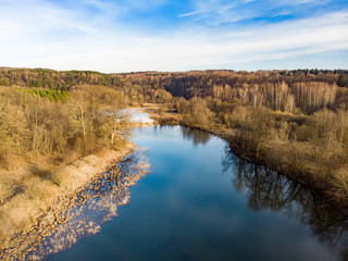 Aerial top down view of lake coast overgrown with sedge and dry grass.