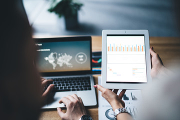 Secretary showing tablet with statistics to businessman