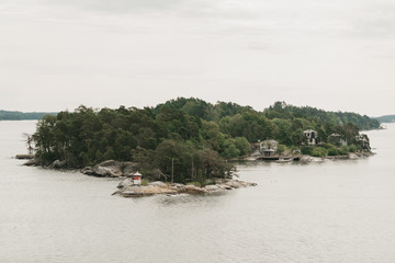 A green rocky peninsula with a forest and a village in the afternoon