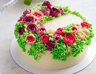 Fototapeta na wymiar Bright festive white cake with bright flowers made of cream, a wedding cake, for a woman.