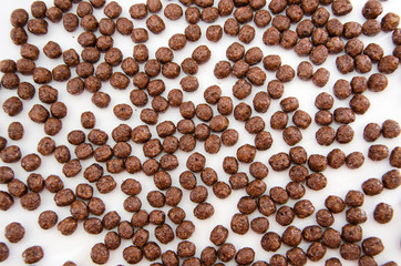Obraz premium Chocolate corn balls as abstract food background. Top view.