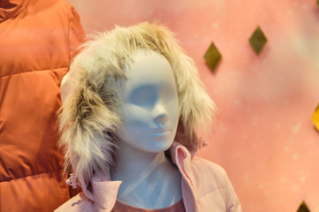 Baby mannequin in warm jacket at shop window