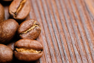 roasted coffee beans on a burnt wooden background. Close up. Copy space.