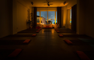 Background image of empty yoga center.  Pilllows with mattres, ambient light and window to big city Istanbul. Hara yoga center in Balat, Istanbul, Turkey.08.11.2019
