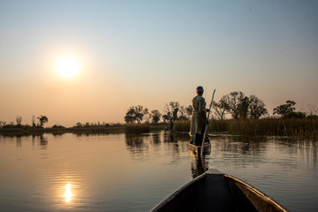 Traditionelle Boote (Mokoros) im Sonnenuntergang im Okavango Delta, Botswana