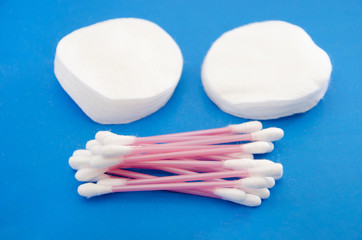 Cotton pads with ear sticks on blue background