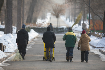 group of janitors with a broom in a park