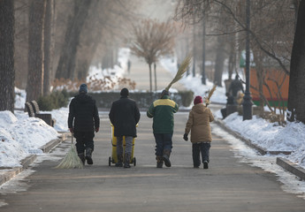group of janitors with a broom in a park