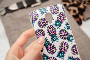 White smartphone case with volumetric pineapple pattern on a wooden background