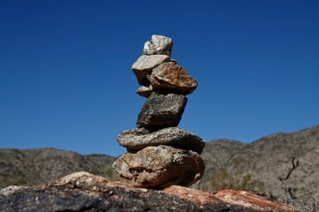 Rocks are piled in a stack known as a ciarn to mark a hikers passage along a trail.