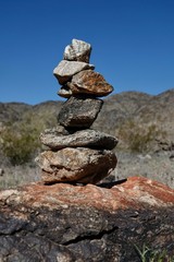 Fototapeta na wymiar Rocks are piled in a stack known as a ciarn to mark a hikers passage along a trail.