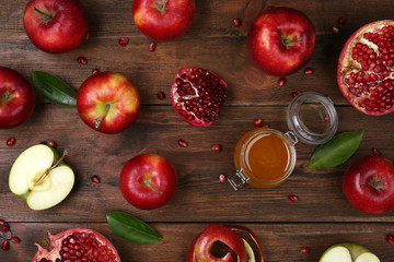 Honey, apples and pomegranate on wooden table, flat lay. Rosh Hashanah holiday