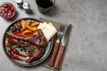Delicious grilled ribs served on light grey table, flat lay. Space for text
