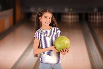 Fototapeta premium Preteen girl with ball in bowling club