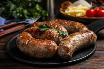 Delicious fresh grilled sausages on wooden table