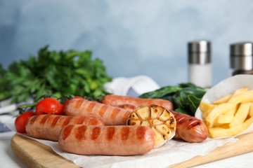 Delicious grilled sausages served on white table