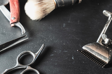 vintage Barber shop equipment on Black background . Professional hairdressing tools. scissor, manual hairclipper, razor, shaving brush