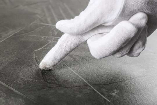 Person In White Glove Checking Cleanliness Of Grey Stone Table, Closeup