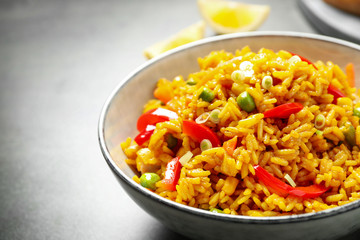 Delicious rice pilaf with vegetables in bowl on table, closeup