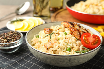 Delicious chicken risotto with tomato on table, closeup