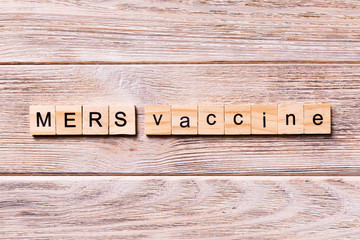 MERS vaccine word written on wood block. MERS vaccine text on wooden table for your desing, coronavirus concept top view