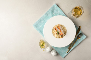 Delicious chicken risotto served on light grey table, flat lay. Space for text