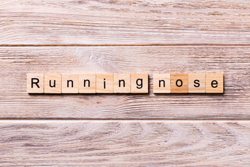 running nose word written on wood block. running nose text on wooden table for your desing, coronavirus concept top view