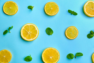 Fototapeta na wymiar Lemonade layout with juicy lemon slices and mint on light blue background, top view