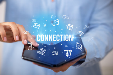 Businessman holding a foldable smartphone with CONNECTION inscription, social media concept
