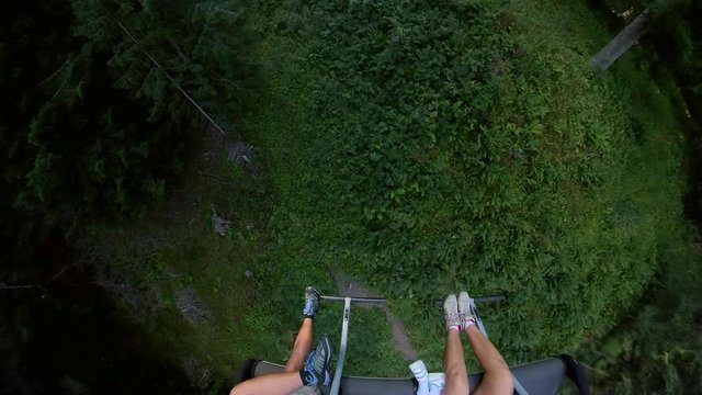 Famiglia in seggiovia che sale verso la vetta della montagna in estate