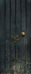 Fototapeta premium old wooden door with golden knob and vertical panels - rough texture with scratches and dark blue texture
