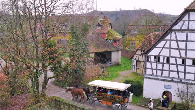 Carruaje de tiro de dos caballos percherones paseando por pueblo rural de granjas de madera