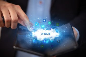 Businessman holding a foldable smartphone with UPDATE inscription, technology concept