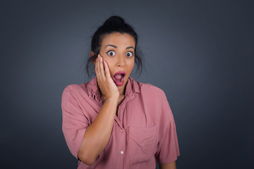 Surprise astonished beautiful girl. Closeup portrait woman looking surprised in full disbelief wide open mouth with hand near face. Positive emotion facial expression body language. Funny girl