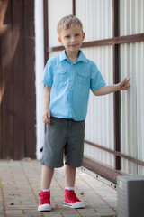 Cute fair-haired boy is playing outside.